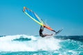 Windsurfer catching wave with board and colorful sail Royalty Free Stock Photo