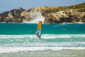 Windsurfer finishing training and a surfer waiting the wright wave