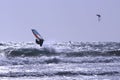 Windsurfer jumping and kitesurfer in the distance at the Atlantic ocean Royalty Free Stock Photo