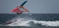 Windsurfer jumping over a big wave balancing Royalty Free Stock Photo