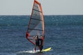 Windsurfing. A windsurfer rides on the sea in calm, light wind. Royalty Free Stock Photo