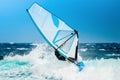 Windsurfer riding the waves with the white sail Royalty Free Stock Photo