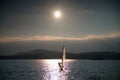 Windsurfer sailing into breeze Shot with gentle filter. Strong sun makes reflections. Royalty Free Stock Photo