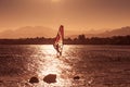 Windsurfer sailing in sea at sunset Royalty Free Stock Photo