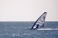 Windsurfer silhouette against a sunset background. Windsurfer Surfing The Wind On Waves, Recreational Water Sports Royalty Free Stock Photo