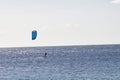 Windsurfer silouetted against a bright ocean background.
