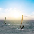 Windsurfer surfing the wind on emerald sea waves at the sunset Royalty Free Stock Photo