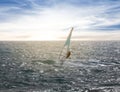 windsurfer surfing the wind on emerald sea waves at the sunset Royalty Free Stock Photo