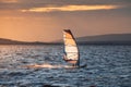 Windsurfer Surfing The Wind On Waves at Sunset Royalty Free Stock Photo