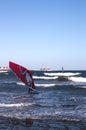A windsurfer travels on the water