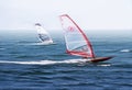 Windsurfers riding the waves of the beautiful blue sea