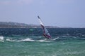 Windsurfing girl gliding over the blue choppy sea Porto Pollo, Sardinia, Italy Royalty Free Stock Photo