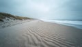 Windswept sand patterns create textured lines on coastal beach. Grasses line dunes bordering sandy shore. Ocean waves gently roll Royalty Free Stock Photo