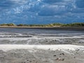 Strong sea breeze in dune landscape by dark-blue clouded sky Royalty Free Stock Photo