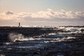 Windy late evening sunset view to Baltic sea lighthouse with large storm waves Royalty Free Stock Photo