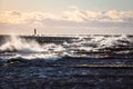 Windy late evening sunset view to Baltic sea lighthouse with large storm waves Royalty Free Stock Photo