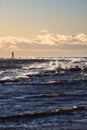 Windy late evening sunset view to Baltic sea lighthouse with large storm waves Royalty Free Stock Photo