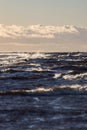 Windy late evening sunset view to Baltic sea lighthouse with large storm waves Royalty Free Stock Photo