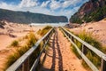 Windy morning view of Cala Domestica beach. Exciting summer scene of Sardinia, Italy, Europe. Footbridge in Canyon di Cala Domesti Royalty Free Stock Photo