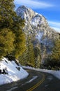 Windy mountain road after the snow was recently plowed away. Royalty Free Stock Photo