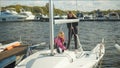 In windy weather in the marina, the women`s sailing team prepares the yacht to participate in the river regatta. Royalty Free Stock Photo