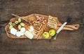 Wine appetizers set: cheese selection, honey, grapes, almonds, walnuts, bread sticks, figs on olive wood serving board