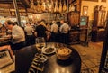 Wine bar with eating people under dry-cured ham legs and wooden vintage decor