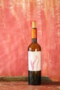 Wine bottle with blank label, free copy space, grungy red background. Wine, winetasting, wine season mock up