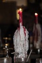 Wine bottle candle holder covered with wax holding lit candle sitting on a bar reflected in a mirror Royalty Free Stock Photo