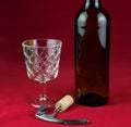 Wine Bottle with Corkscrew and Cork and Wine Glass on a Mottled Red Background Royalty Free Stock Photo