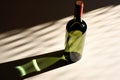 wine bottle at a diagonal angle casting long shadows