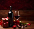 wine bottle and glass, accompanied by roses and a box of chocolates, symbolizing a romantic date Royalty Free Stock Photo