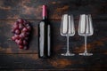 Wine Bottle and glass of Red wine with ripe grapes, on old dark  wooden table , top view flat lay Royalty Free Stock Photo