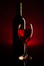 Wine bottle and glass silhouette over dark red