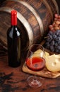 Wine bottle, grapes, cheese and glass of red wine Royalty Free Stock Photo