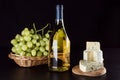 Wine bottle, grapes in a wicker basket and blue cheese Royalty Free Stock Photo