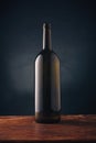 Wine bottle without label, no brand mockup on dark wooden background. Alcohol drink, vertical close up shot Royalty Free Stock Photo