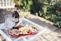 Wine bottle mockup with blank stickers. Ice cooler, two glasses of champagne and plate of delicious dessert on glass table Royalty Free Stock Photo