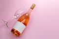 Wine bottle mockup, unopened bottle of rose wine and a glass on pink background Royalty Free Stock Photo