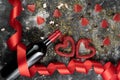 Wine bottle with a red satin ribbon and two hearts. Valentine's Day. On a white and black concrete background. Free Royalty Free Stock Photo