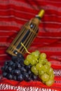 Wine bottle, red and white grapes on a traditional Royalty Free Stock Photo