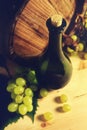 Wine bottle, wooden barrel and white grapes. Royalty Free Stock Photo