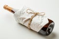 A wine bottle wrapped in white paper, mockup isolated on white background Royalty Free Stock Photo