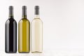 Wine bottles collection different colors - transparent, green, black- on white wooden board, mock up, copy space.