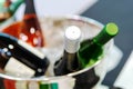 Wine in bottles is cooled in a metal bucket. Different types of alcoholic drinks prepared for the party