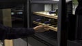 Wine bottles cooling on refrigerator wooden shelves. Household utensils. Close up of home use wine cooler, man opens the Royalty Free Stock Photo