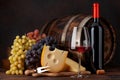 Wine bottles, grapes, cheese, glass of red wine and old barrel Royalty Free Stock Photo