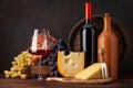 Wine bottles, grapes, cheese, glass of red wine and old barrel Royalty Free Stock Photo