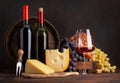 Wine bottles, grapes, cheese, glass of red wine and old barrel Royalty Free Stock Photo