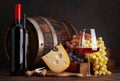 Wine bottles, grapes, cheese and glass of red wine Royalty Free Stock Photo